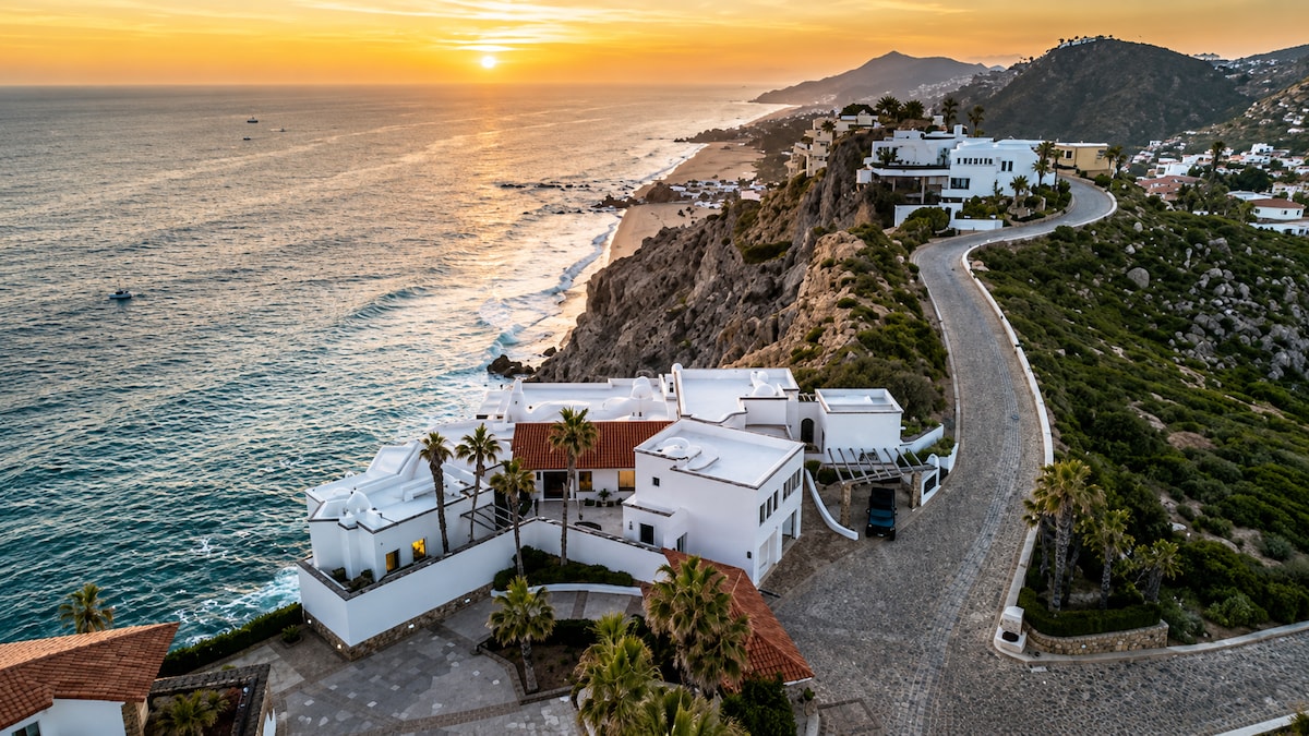 Aerial sunset view of VIP Cliffside Villa in Pedregal, Cabo San Lucas, on a rocky cliff above the Pacific