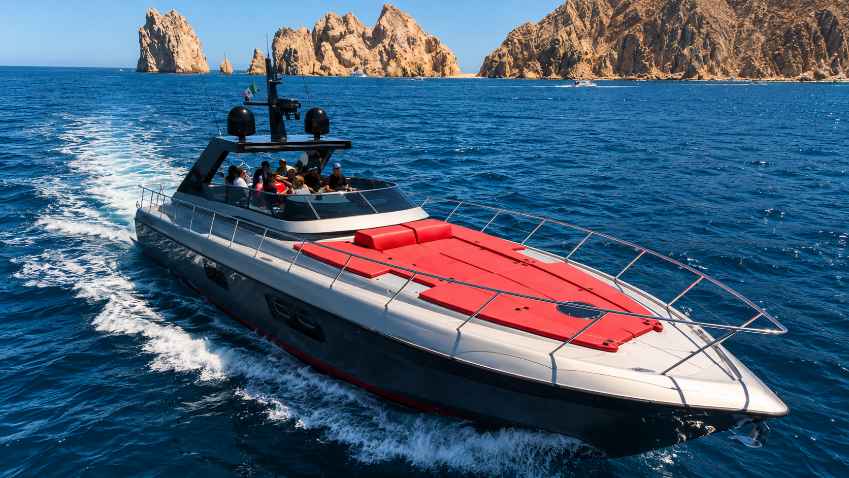 Silver 65ft yacht with red bow sunpad, El Arco aerial