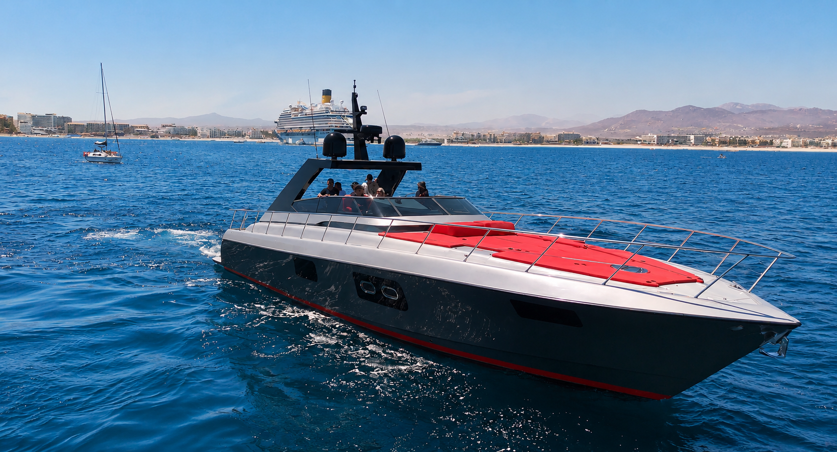 Three-quarter view of 65ft yacht, red waterline, Cabo hotels and cruise ship